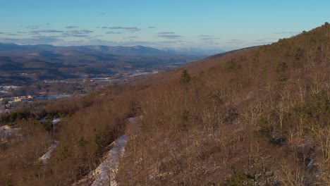 Aerial-drone-footage-of-a-beautiful,-colorful-sunset-of-the-snowy-Appalachian-mountains-during-winter