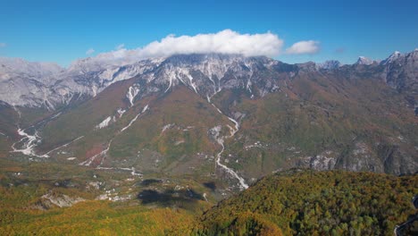 Herbstfarben-Im-Atemberaubenden-Alpental,-Umgeben-Von-Hohen-Bergen-Unter-Wolken-Und-Blauem,-Klarem-Himmel
