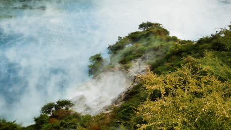 Top-down-shot-of-Toxic-Sulfur-Steam-flying-over-Inferno-Crater-Lake-during-sunlight---Waimangu,New-Zealand