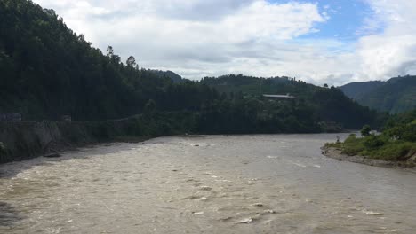 Ein-überschwemmungsfluss-Im-Schatten-Der-Hügel-Von-Nepal