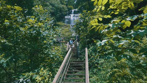 Epic-slow-motion-footage-of-people-walking-up-a-bridge-to-Amicalola-Falls,-the-largest-waterfall-in-all-of-Georgia
