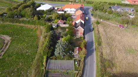 Fliegen-über-Landwirtschaftliches-Ackerland-Mit-Straße-Und-Häusern-In-Norfolk,-England---Drohnenaufnahme-Aus-Der-Luft