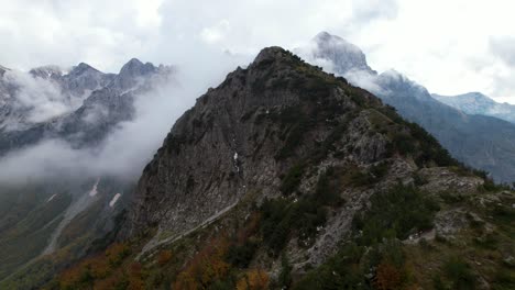 Mountain-peak-in-the-Alps-with-misty-background-and-colorful-foliage-in-Autumn