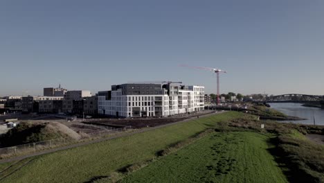 Complejo-De-Apartamentos-Kade-Noord-En-La-Orilla-Del-Río-Ijssel-Con-Grandes-Grúas-Rojas-Detrás-En-El-Barrio-Noorderhaven-Recientemente-Desarrollado-En-Zutphen
