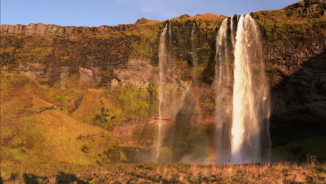 Statische-Weitwinkelaufnahme-Des-Isländischen-Wasserfalls-Seljalandsfoss-Mit-Regenbogenreflexion-Bei-Sonnenuntergang-In-Island