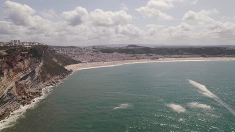 Aerial-view-of-beach-of-Nazare,-seaside-town-and-Atlantic-ocean,-Portugal