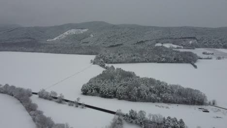 Drohne-Fliegt-Hoch-über-Winterlandschaft-Mit-Bergen-Mit-Schnee