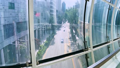View-Of-Orchard-Road-Through-Glass-Wall-Of-Orchard-Gateway-Bridge-In-Singapore