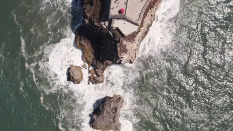 Vertical-top-down-view-of-clifftop-old-Saint-Michael-the-Archangel-fort-and-Nazare-lighthouse