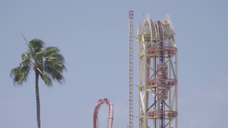 Epic-close-up-shot-of-a-roller-coaster-climbing-a-lift-hill,-and-then-plunging-down-into-a-giant-loop