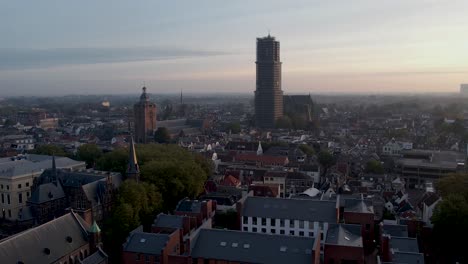 Speelklok-museum-and-De-Dom-cathedral-tower-rising-up-above-the-rooftops-of-medieval-historic-city-center-of-Utrecht-in-The-Netherlands-at-sunrise