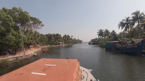 Banks-of-navigable-canal-of-Alappuzha-or-Alleppey-seen-from-bow-of-boat-in-movement,-India