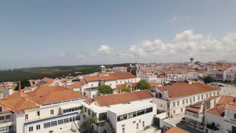 Cinematic-pan-shot-overlooking-beautiful-Nazare-cityscape-and-famous-church-at-central-square