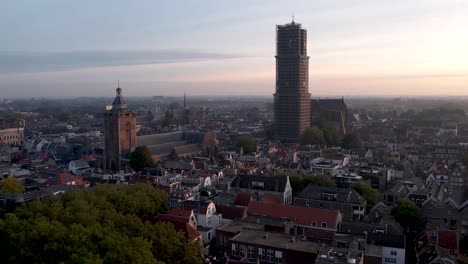 De-Dom-medieval-cathedral-tower-in-scaffolding-and-museum-Speelklok-at-sunrise-in-city-centre-of-Utrecht-towering-over-the-cityscape-turning-towards-central-station-Hoog-Catharijne