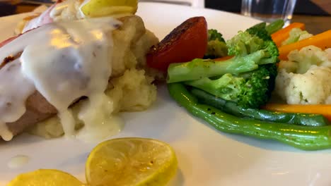 A-plate-of-grilled-fish-saltimboca-and-steamed-vegetables-at-a-local-restaurant