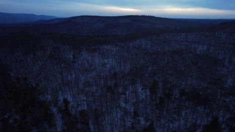 Aerial-drone-video-footage-of-nightfall-in-the-snowy-appalachian-mountains-during-winter,-in-the-Catskill-Mountains-sub-range