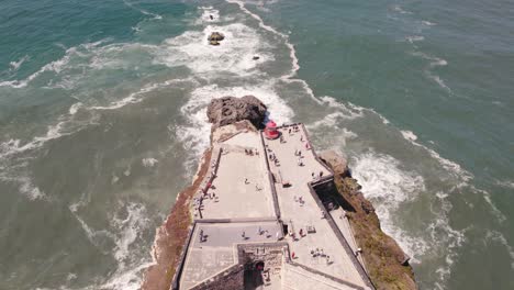 Aerial-view-tourists-on-Nazaré-lighthouse-descending-reveal-Atlantic-Ocean-horizon