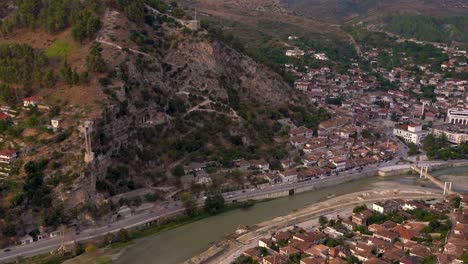 Slow-tilt-up-over-beautiful-ancient-village-of-Berat-with-castle-at-sunset