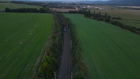 Aerial-view-of-a-train-viaduct-with-a-passing-train-and-the-surrounding-countryside-and-city-in-the-background