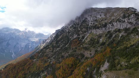 Montañas-épicas-En-Los-Alpes-De-Albania,-Nubes-Sobre-Picos-Altos-Y-Coloridos-árboles-Forestales