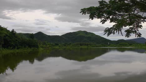 4K-B-Roll-Footage-of-a-Lake-Surrounded-by-Hillside-Mountains-and-Green-Forest-Trees-in-Thailand
