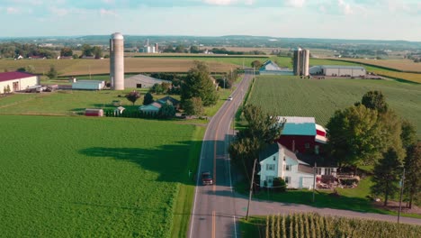 Country-road-cuts-through-rural-fields-and-farmland-in-America