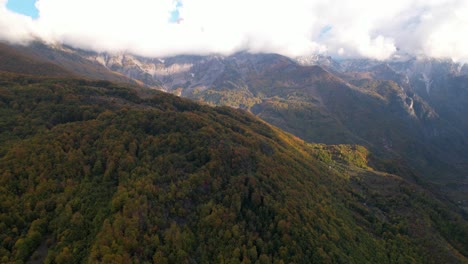 Mountains-under-clouds-in-Autumn,-colorful-foliage-of-wild-forest-in-Albania