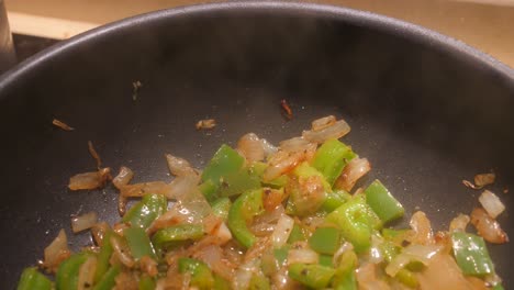Sauteing-Green-Bell-Peppers-And-Onions-In-A-Frying-Pan