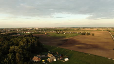 Flying-over-lonely-homestead-revealing-majestic-town-of-Ringaudai,-aerial-drone-view