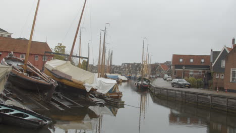 Old-Dutch-botter-boat-in-maintenance-dock-in-canal-running-through-small-fishing-village-in-the-Netherlands