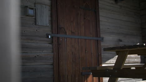 Locked-wooden-door-of-rural-building,-reveal-motion-view