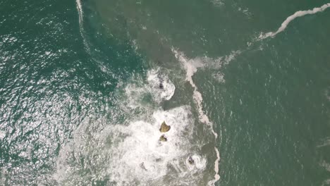 Vertikaler-Gerader-Blick-Nach-Unten-Auf-Das-Schöne-Meerwasser,-Das-Auf-Felsen-In-Nazare,-Portugal,-Abstürzt