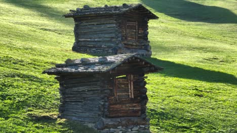 Two-old-wooden-huts-on-a-mountain-meadow-in-the-Alps