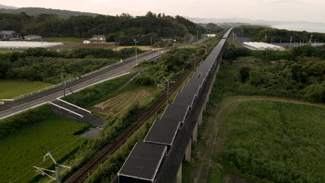 Aerial-Tilting-Down-To-Solar-Panels-Installed-On-An-Abandoned-Monorail-Track-In-Japan