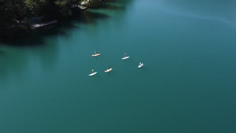 Luftaufnahme-Von-Menschen-Standup-Paddleboarding-Am-Bleder-See-In-Slowenien