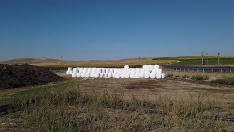 Wrapped-and-Stacked-Bales-of-Hay-near-Solar-Panels