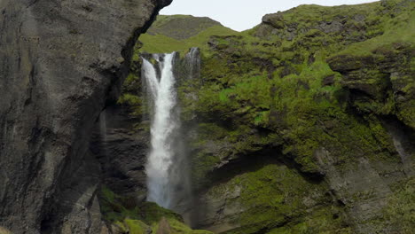 Cascada-Kvernufoss-Corriendo-Sobre-Acantilados-Cubiertos-De-Musgo-En-El-Sur-De-Islandia