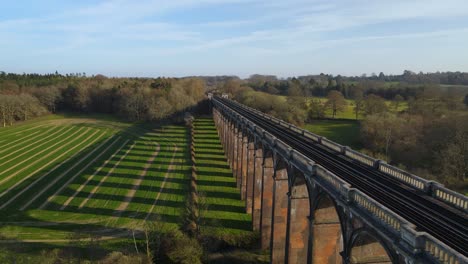 Aerial-drone-flyback-along-Ouse-Valley-or-Balcombe-viaduct-surrounded-by-verdant-landscape,-Sussex