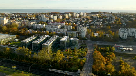 Drone-shot-of-PPNT-Park-and-Apartment-Blocks-in-Gdynia-City-with-Baltic-Sea-in-background---Beautiful-golden-sunrise-morning-on-coastal-city