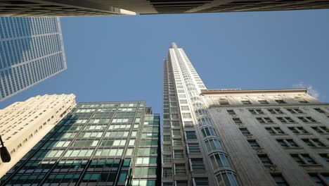Hohe-Moderne-Gebäude-In-Der-Innenstadt-Von-Stadt-Mit-Hochhaustürmen,-Die-Zum-Klaren-Blauen-Himmel-Aufblicken