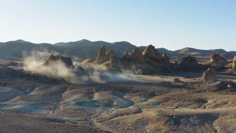 Cinematic-establishing-shot-of-the-trona-pinnacles-covered-with-dust-overlooking-mountain-range