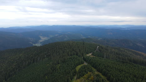 Aerial-view-of-the-top-of-the-hills-with-the-forest-lying-below-and-lots-of-smaller-peaks-and-nature