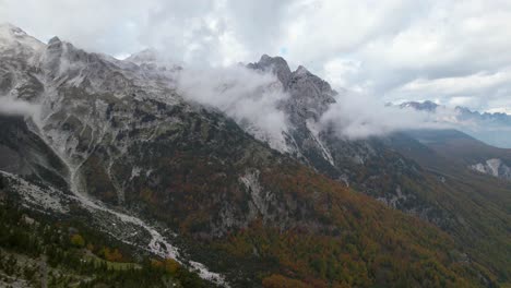 Panorama-Der-Alpenberge-In-Albanien-Mit-Felsigem-Hang,-Der-Mit-Nebel-Und-Goldenen-Bäumen-Bedeckt-Ist