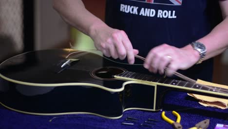 Restringing-and-cleaning-a-beautiful-black-single-cutaway-accoustic-guitar---removing-the-strnigs-from-the-bridge-end