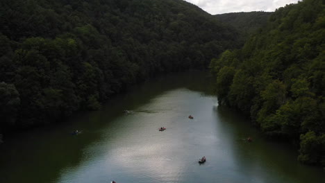 Drone-shot-of-river-near-Lilafured,-Hungary-with-boaters-on-the-water