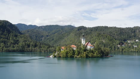 Vista-Sobre-El-Lago-Bled-Y-La-Isla-Con-La-Iglesia-De-Peregrinación-Dedicada-A-La-Asunción-De-María-En-Eslovenia---Toma-De-Drones