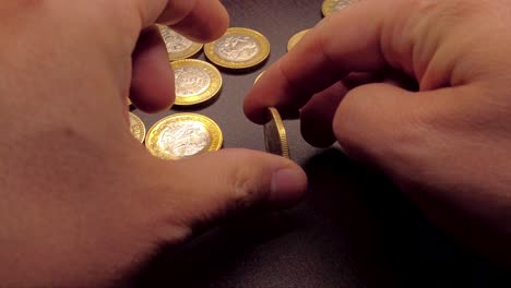 Moneda-Girando-A-Mano-Sobre-Una-Mesa-De-Madera