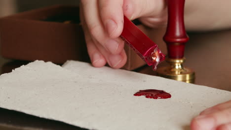 Dripping-hot-wax-onto-a-piece-of-parchment-in-preparation-for-a-wax-seal
