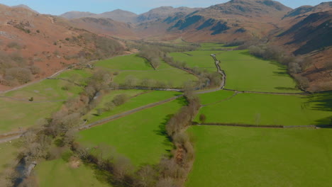 HARDKNOTT-PASS-Lake-District,-Push-forward-through-valley,-elevating-pan-to-reveal-mountains