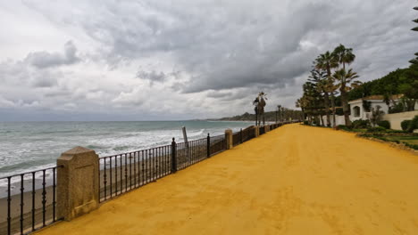 4k-Shot-of-a-wide-footpath-by-the-beach-on-a-cloudy-day-coast-line-in-Marbella,Malaga,-Spain,-Costa-del-sol